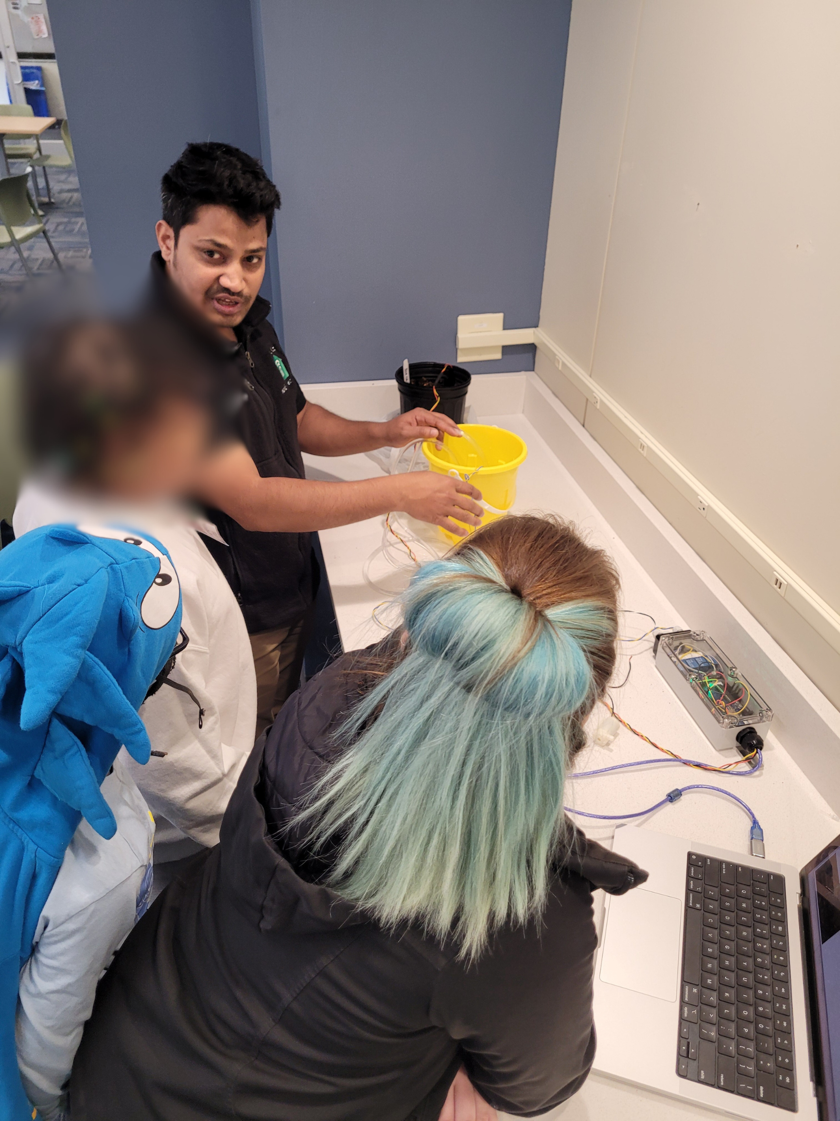 Kids being shown soil moisture sensor